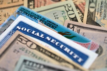 Social security number and permanent resident card with US dollar money bills close up