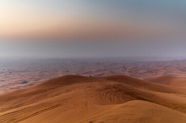 The sun rising on the pristine and untouched red dunes in the desert near Dubai