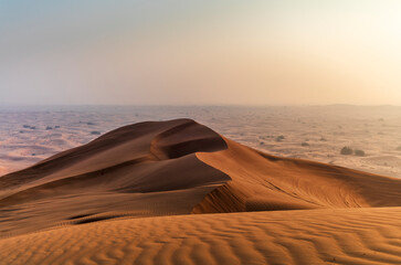 The sun rising on the pristine and untouched red dunes in the desert near Dubai