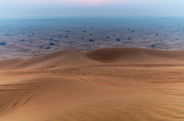 The sun rising on the pristine and untouched red dunes in the desert near Dubai