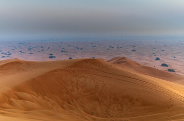 The sun rising on the pristine and untouched red dunes in the desert near Dubai
