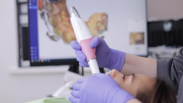 Female adult receiving dental examination with oral 3D scanner technology, top view.