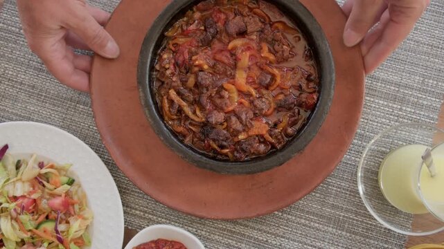 Serving meat and vegetable stew baked in clay pot, top view close-up