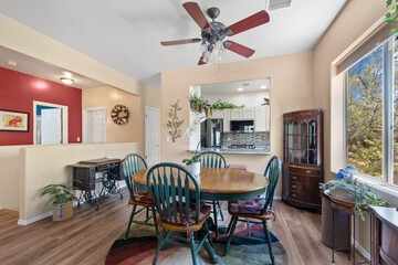 A dining room equipped with a table, chairs, and a ceiling fan for comfort