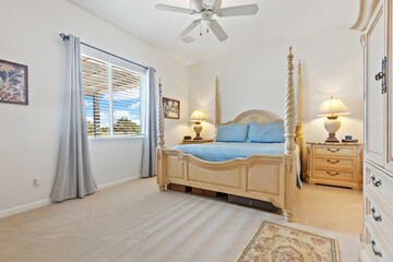A cozy bedroom featuring a spacious king size bed and a ceiling fan overhead