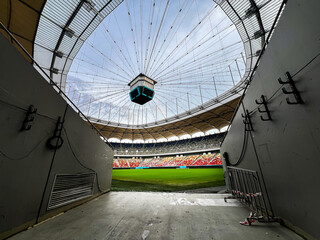 Massive Soccer Stadium tunnel.View of empty stadium. Green grass on a sport Arena. Empty Football Soccer Stadium Tribune. National arena with empty seats. Sport event on National Arena.  © Epic Vision