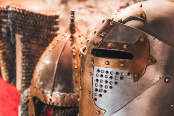 Displaying medieval chainmail armor and two historical helmets showing ancient warrior protection