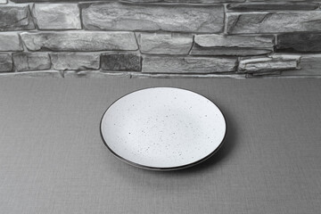 Simple white plate on textured background highlighting minimalist design and subtle details