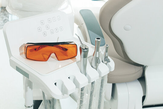 Dental instruments and safety glasses on the module, there are no people in the dental clinic - Powered by Adobe