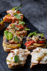 Assorted Gourmet Canaps On Black Slate Board for Elegant Party Platter and Tasting Experience