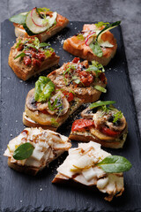 Assorted Gourmet Canaps On Black Slate Board for Elegant Party Platter and Tasting Experience