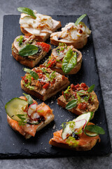 Assorted Gourmet Canaps On Black Slate Board for Elegant Party Platter and Tasting Experience