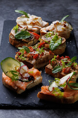 Assorted Gourmet Canaps On Black Slate Board for Elegant Party Platter and Tasting Experience