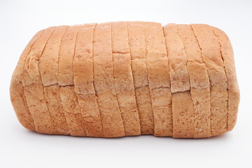 A small, freshly baked loaf of Jamaican sliced whole wheat bread isolated on a white background