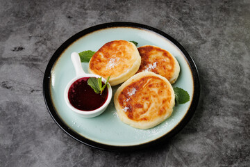 Golden-Brown Cottage Cheese Pancakes With Berry Sauce And Fresh Mint On A Plate For Breakfast Or Dessert