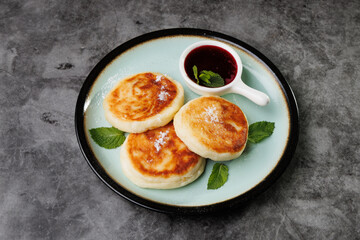 Golden-Brown Cottage Cheese Pancakes With Berry Sauce And Fresh Mint On A Plate For Breakfast Or Dessert