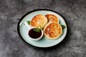 Golden-Brown Cottage Cheese Pancakes With Berry Sauce And Fresh Mint On A Plate For Breakfast Or Dessert
