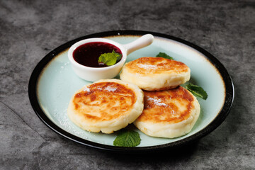 Golden-Brown Cottage Cheese Pancakes With Berry Sauce And Fresh Mint On A Plate For Breakfast Or Dessert