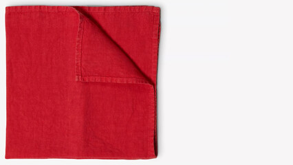 Bright red linen napkin folded neatly on a table surface for a stylish dining setting.