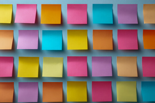 Colorful sticky notes arranged in a grid pattern on a light blue background for organization and brainstorming ideas in office or creative spaces