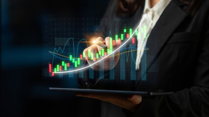 A businesswoman interacts with a digital tablet displaying vibrant financial growth data and graphs, emphasizing the power of technology in finance analysis. Impute