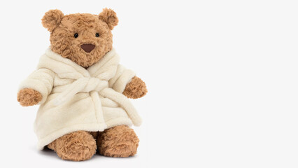 Soft brown bear in a fluffy white robe sitting on a plain background, perfect for cozy moments, playful fun, and comfort for children and adults alike.