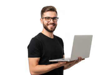 Smiling young man with beard and glasses wearing a black t shirt holding a silver laptop against a stark black background