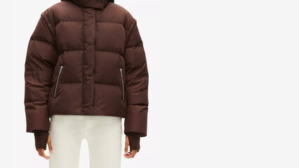 Stylish brown puffer jacket on a person wearing white pants in a minimalistic setting.