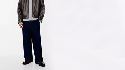 Stylish urban outfit featuring oversized pants and a leather jacket in a minimalist setting.