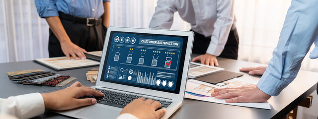 Group of interior architect designer team at table choosing various mood board samples with architecture software on laptop screen. Modern renovation and interior material selection concept. Insight