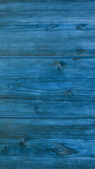 Vibrant blue wooden planks create a striking backdrop with rich texture and depth, inviting creative uses in various crafts and designs.