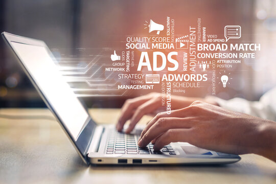 A close-up view of hands typing on a laptop amid various advertising terms, representing the dynamic world of digital marketing and online strategies. Tessel