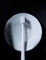 The white toothbrush on the white plate 