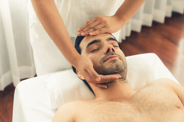 Caucasian man enjoying relaxing anti-stress head massage and pampering facial beauty skin...