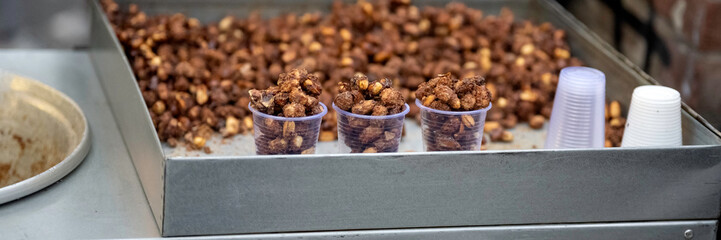 Panorama of Candied mixed nuts in cups at a food market