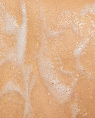 Macro photo of soapy foam texture on wet skin