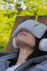 Enjoy the soothing experience of relaxing outdoors while wearing headphones and an eye mask