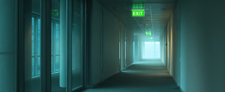 Modern office building hallway featuring emergency exit sign and glass walls,National Energy Conservation - Powered by Adobe