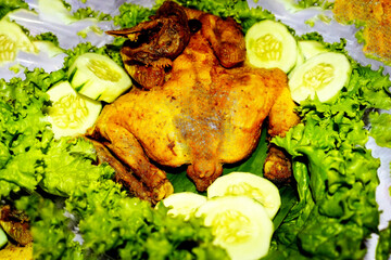 Whole Fried Chicken with Lettuce and Cucumber Garnish