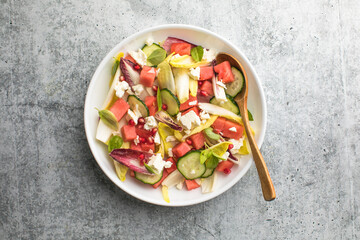Fresh chicory Endive salad with watermelon, cucumber, and feta cheese, top view.