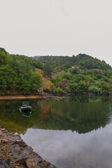 Rio, montañas y lancha en un día lluvioso de otoño