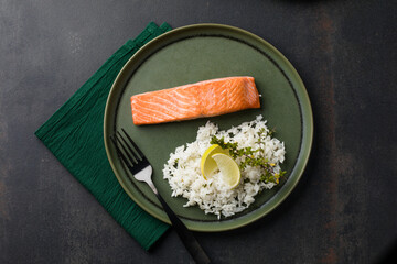 Cooked salmon fllets with rice  on green background