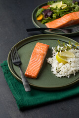 Cooked salmon fllets with rice  on green background