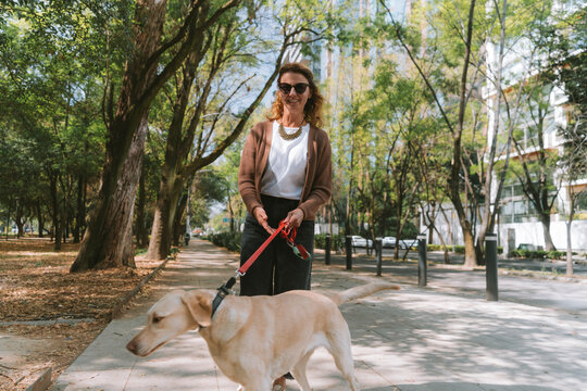 A woman is walking her dog along a tree-lined path in Mexico City&rsquo;s Polanco neighborhood