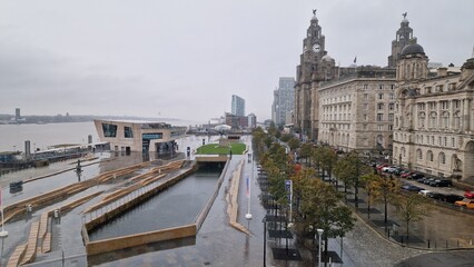 Aerial view of busy urban transport hub with buses, commuters and wet streets, showing routine city life and modern public infrastructure.