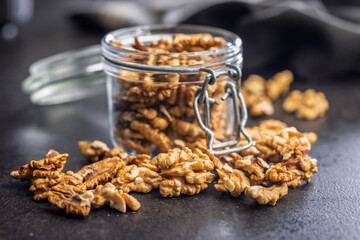 Peeled walnut kernels on black table.