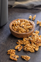 Peeled walnut kernels on black table.