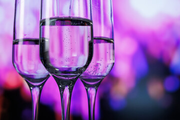 stylish stemmed glasses highlight effervescent drinks amidst colorful neon lighting for nightlife promotion