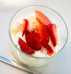 Natural yoghurt made from farm milk with strawberries view from above. Appetizing Greek yogurt with berries for dessert