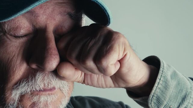 Old Man Rubs His Eyes in Discomfort